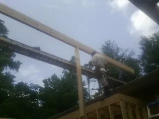 Carpenter setting a ridge beam over a new addition frame — Ice Dam Removal by Roofing Brothers in Pattison