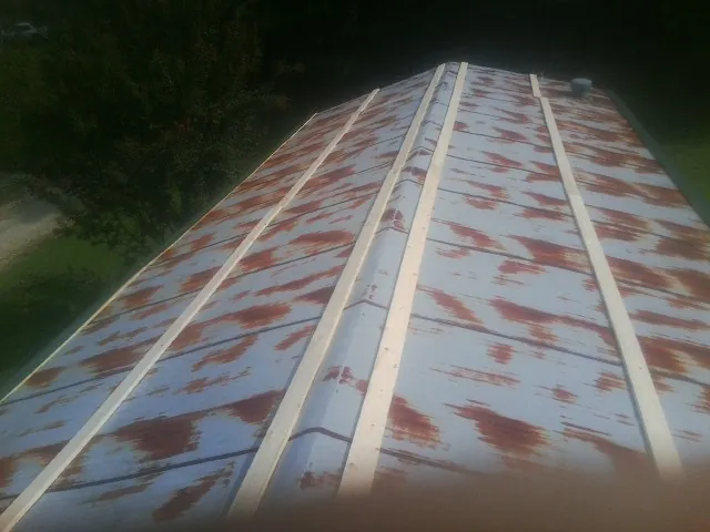 Rusted metal roof panels with new wood purlins before replacement — Storm Damage Roof Repair in Pattison by Roofing Brothers