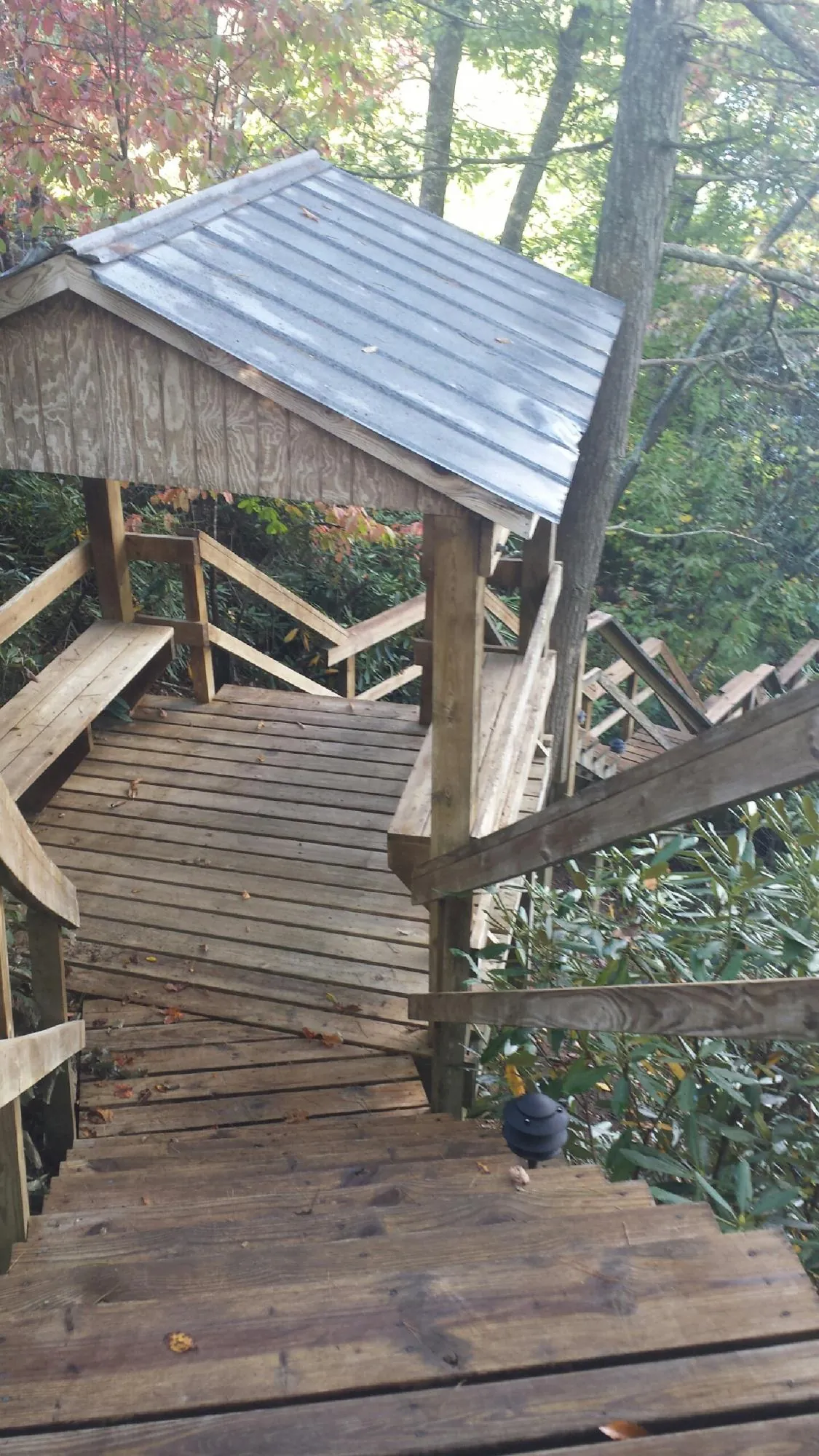 Metal roofed shelter over wooden steps on a wooded walkway — Skylight Repair & Installation work by our crew in Pattison
