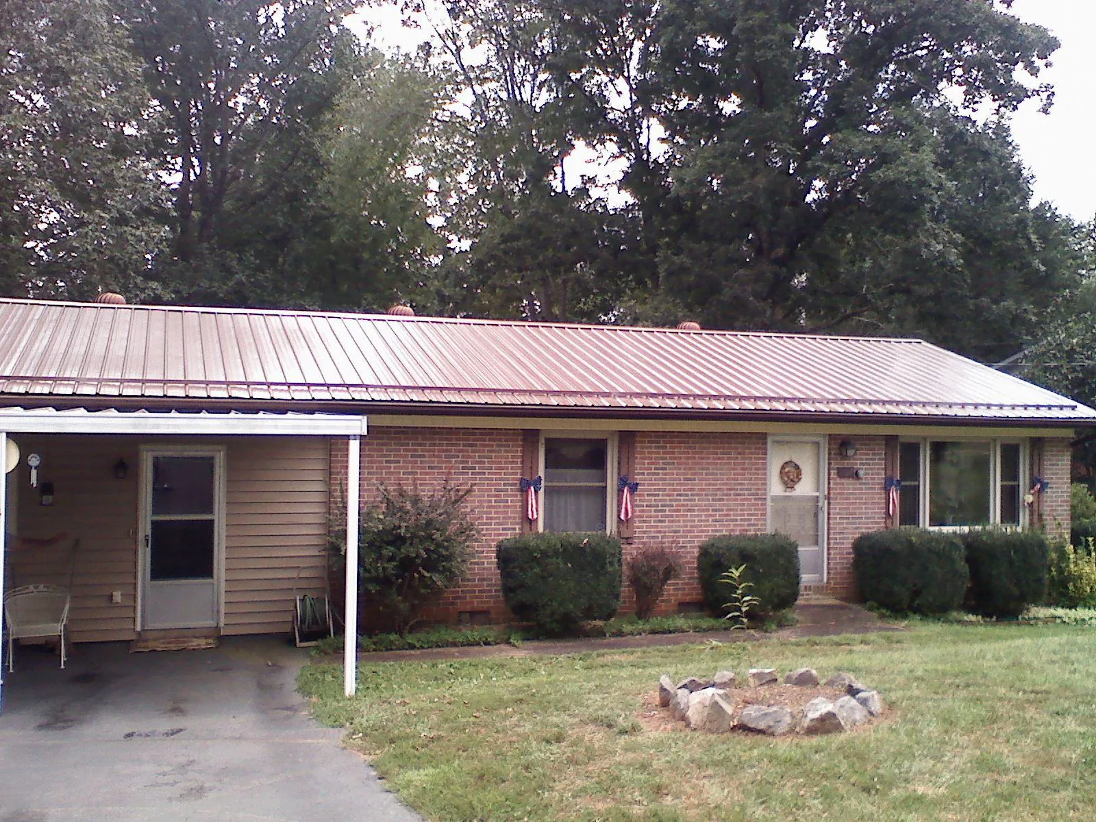 Bronze metal roof and carport on a brick ranch home — Roof Repair work by our crew in Pattison